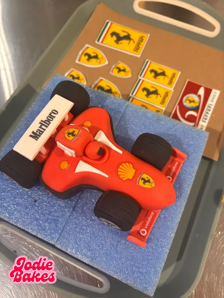 Handmade red Formula 1 racing car cake topper with sugar decals, by Jodie Bakes, Leeds