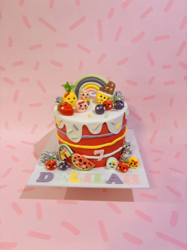 Rainbow and fruit 7th birthday drip cake with a personalised name plaque, by Jodie Bakes, Leeds